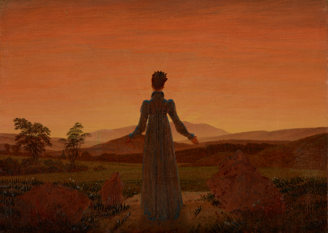 夕日の前に立つ女性